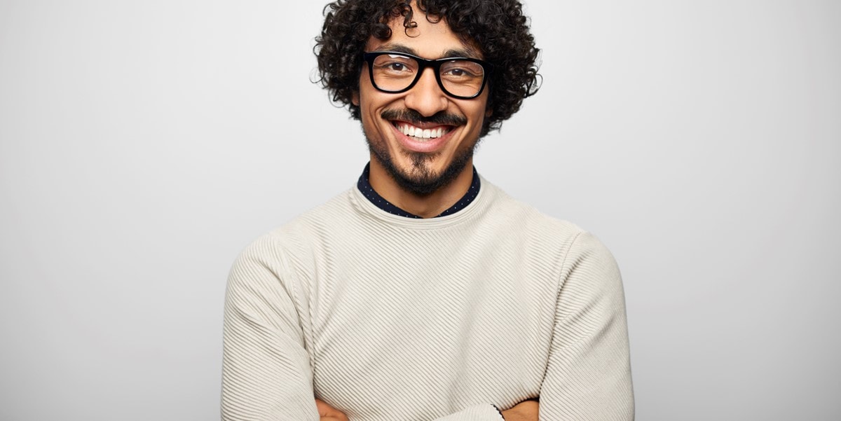 hombre sonriendo con brazos cruzados