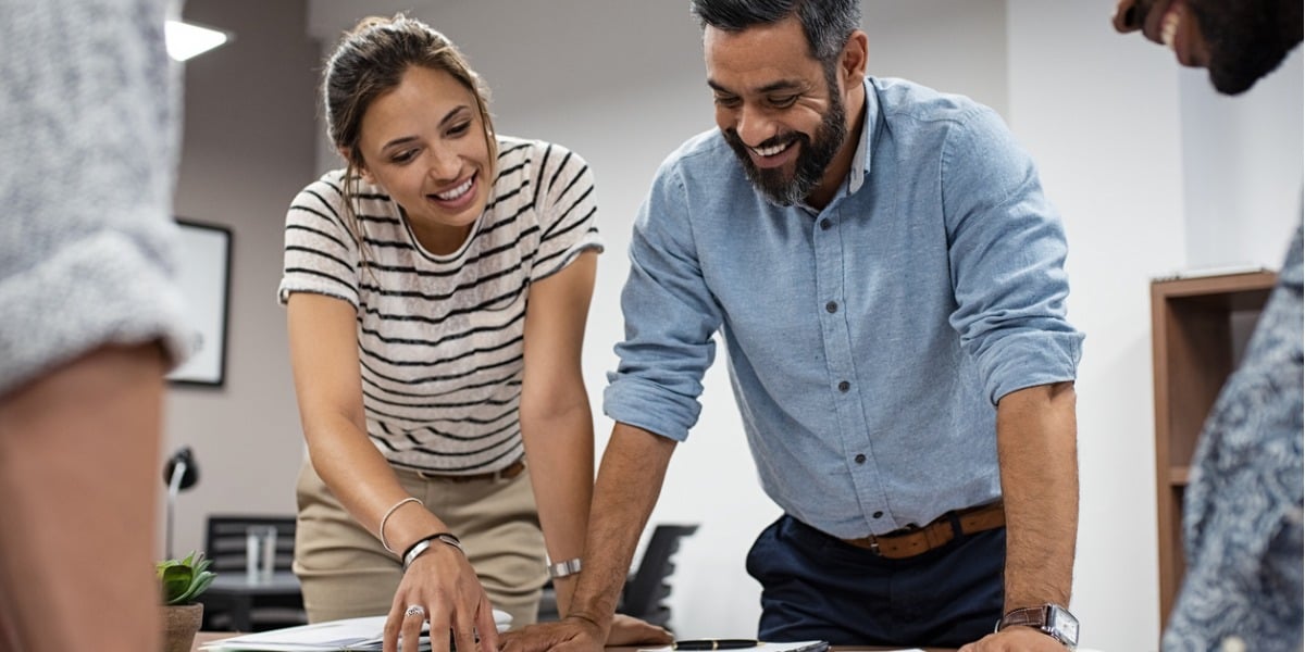 two people working smiling and working together 