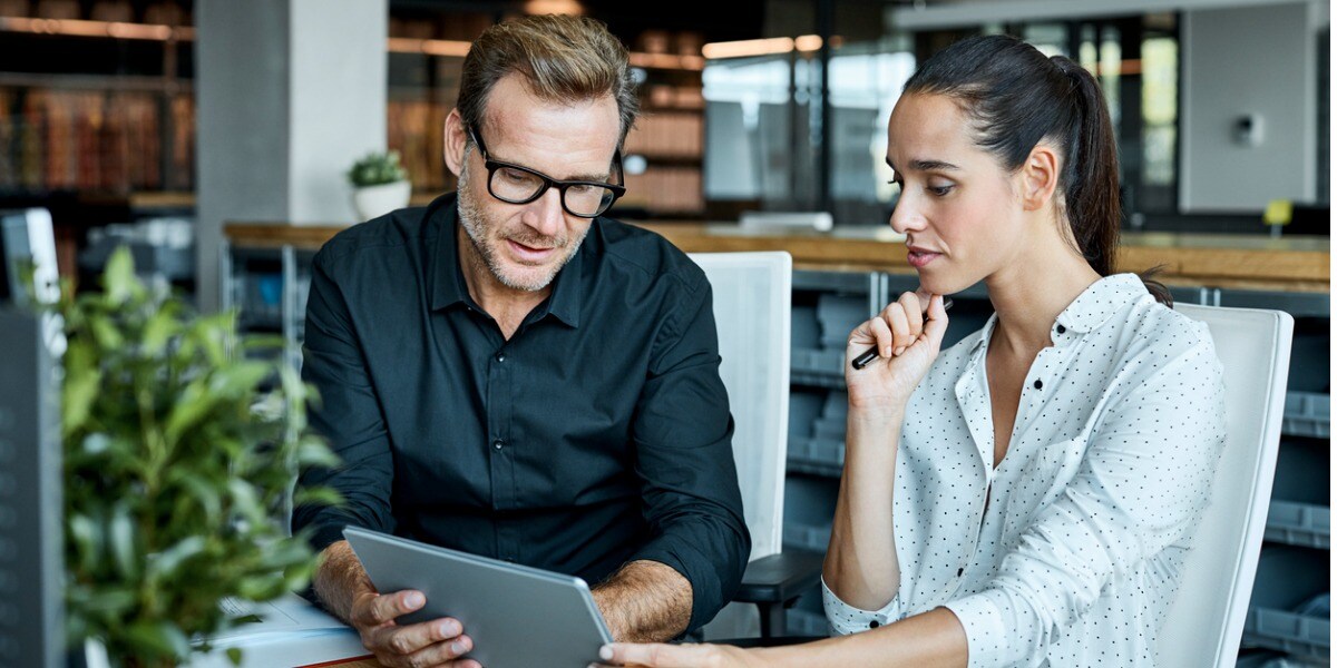 people talking and working on a laptop