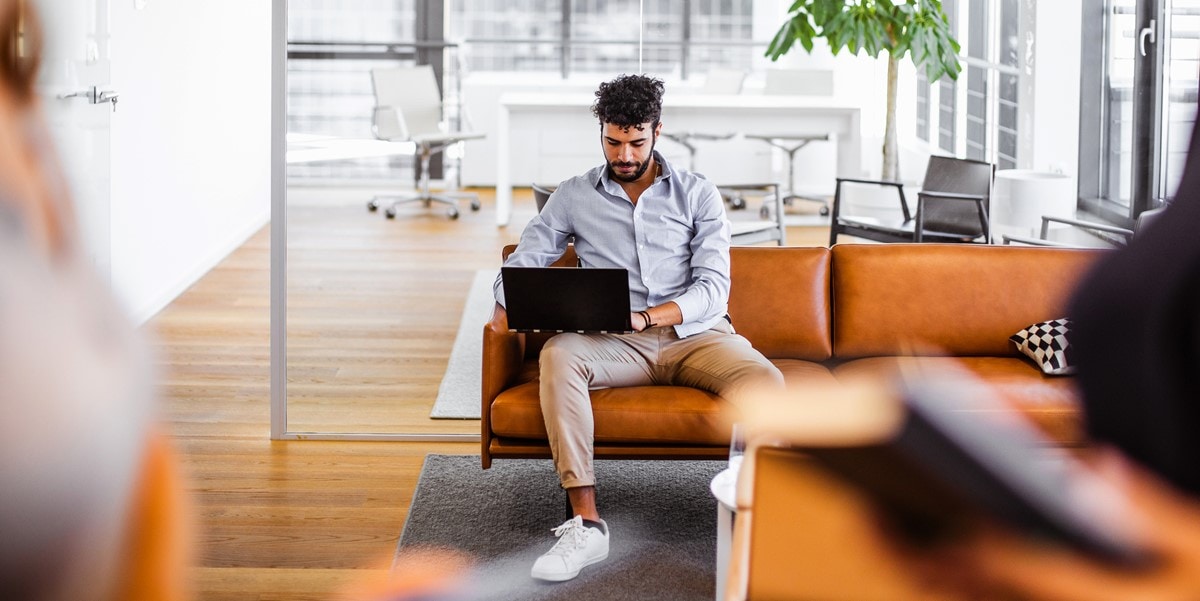 man at office looking at laptop