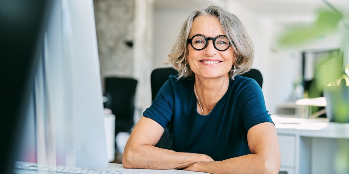 smiling businesswoman at a desk in an office