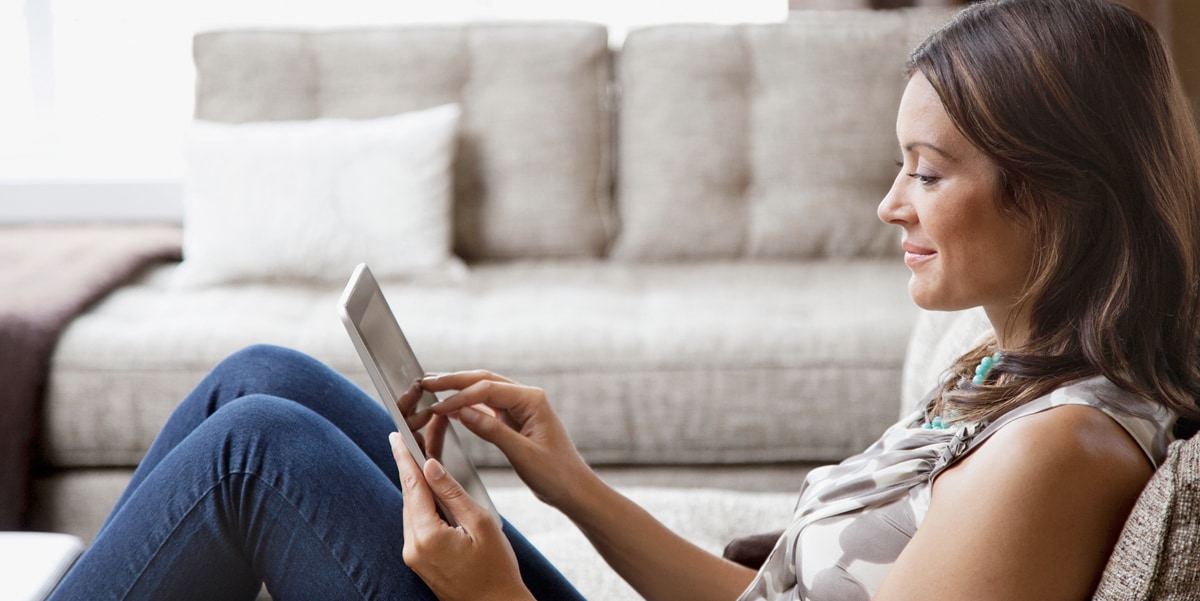 woman sitting on a coach with a tablet