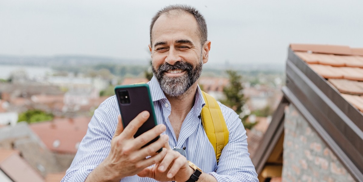traveler standing outside of building using cell phone