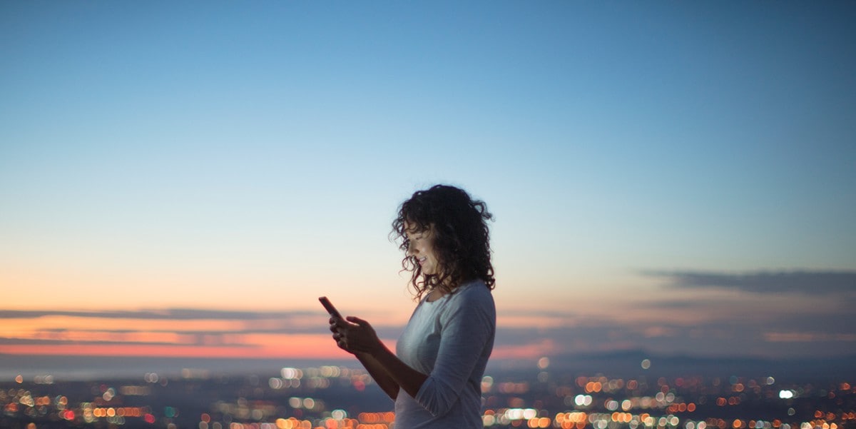 woman using cellphone, standing outside