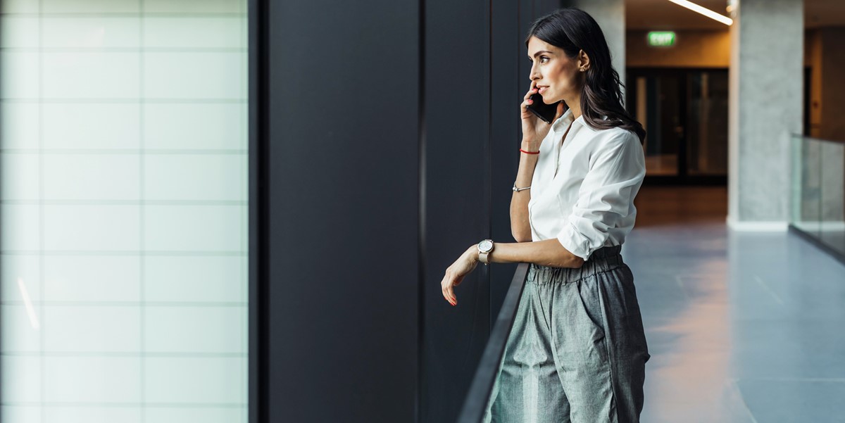 businesswoman on the phone, standing by window in the office