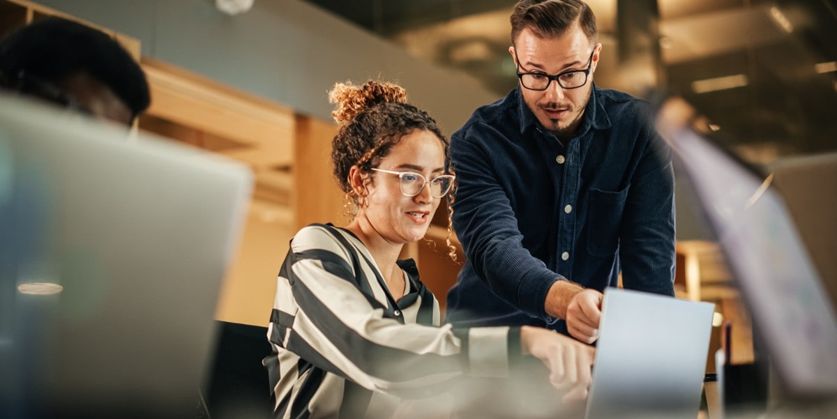 two professionals looking at computer, in the office