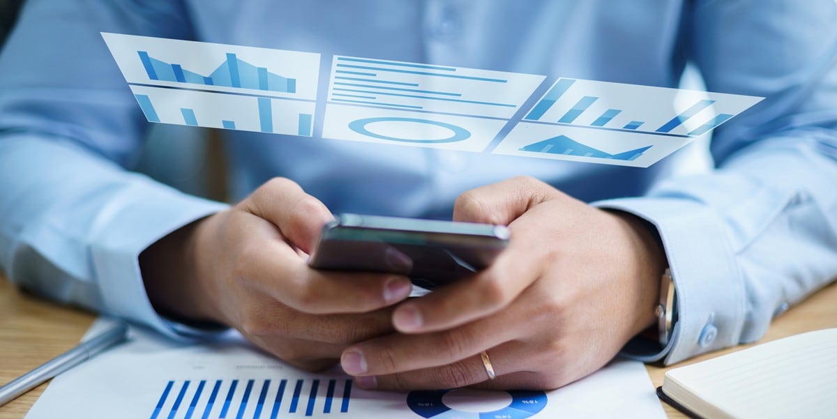 hands using cell phone, chart graphic floating above the users hands
