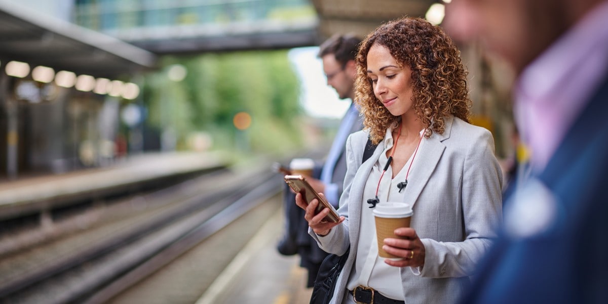 woman traveler using phone at train stop