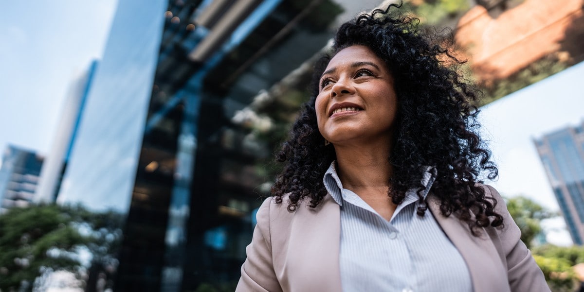 professional woman smiling standing outside office building