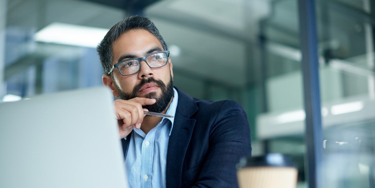 professional man in office sitting at desk with laptop