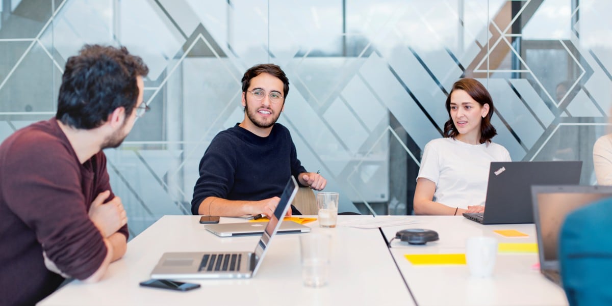 3 professionals seated at a conference table