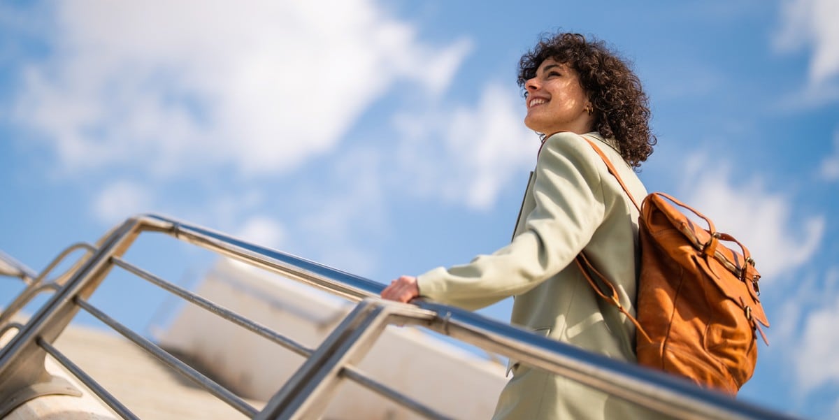 woman with backpack going upstairs