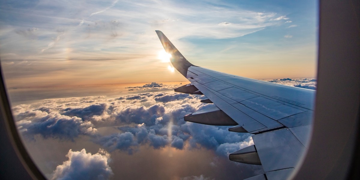 sky and airplane wing view from interior window
