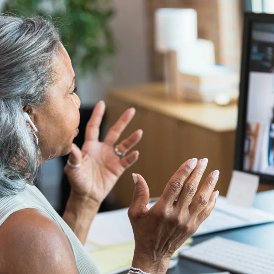 woman working at desk, attending a virtual meeting